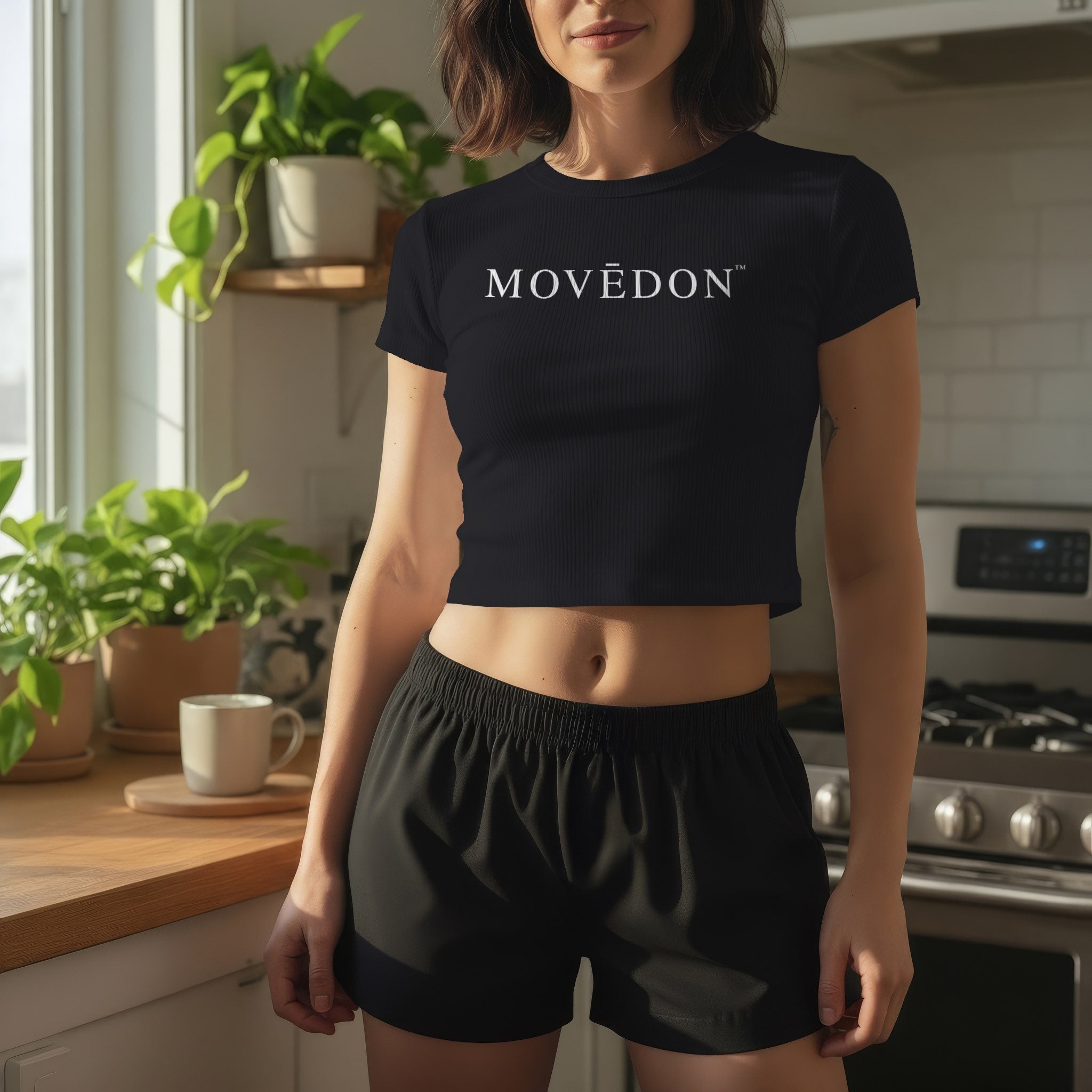 Model wearing the black MOVĒDON fitted baby crop tee